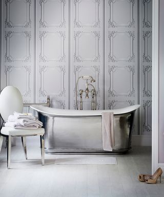 A silver bath tub in front of a grey panelled wall from best bathroom designers Catchpole & Rye.