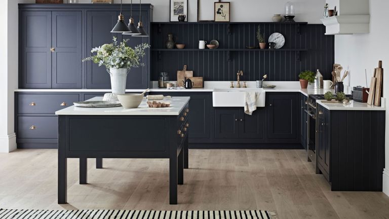 dark navy kitchen with white worktops and striped rug