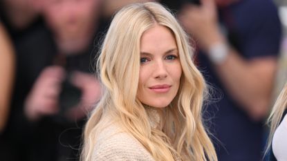 Sienna Miller wears blonde curls with a minimalist, natural makeup look and rosy lipstick