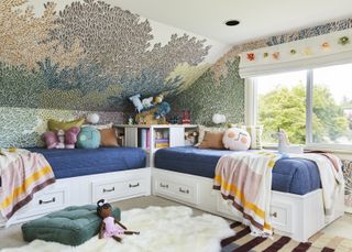 A kids' room with two day bed perpendicular to one another decorated with cushions and soft toys