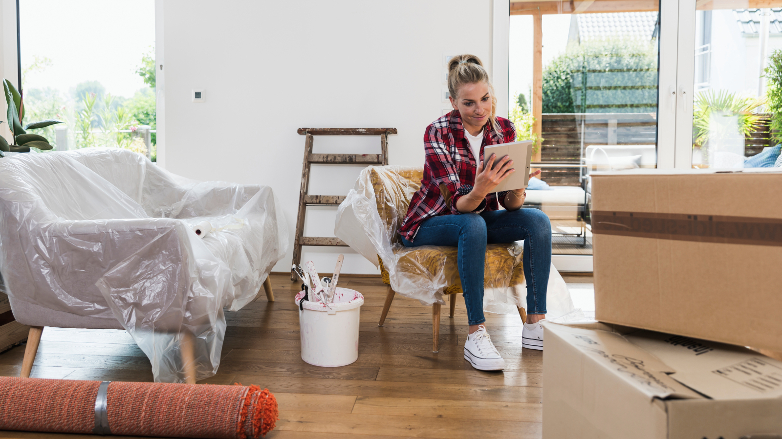 female sat on plastic covered chair in partially renovated living room