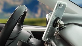Nite ize car mount pictured on a car dashboard with a silver iPhone attached.