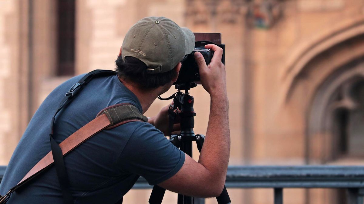 photographer pointing towards a building