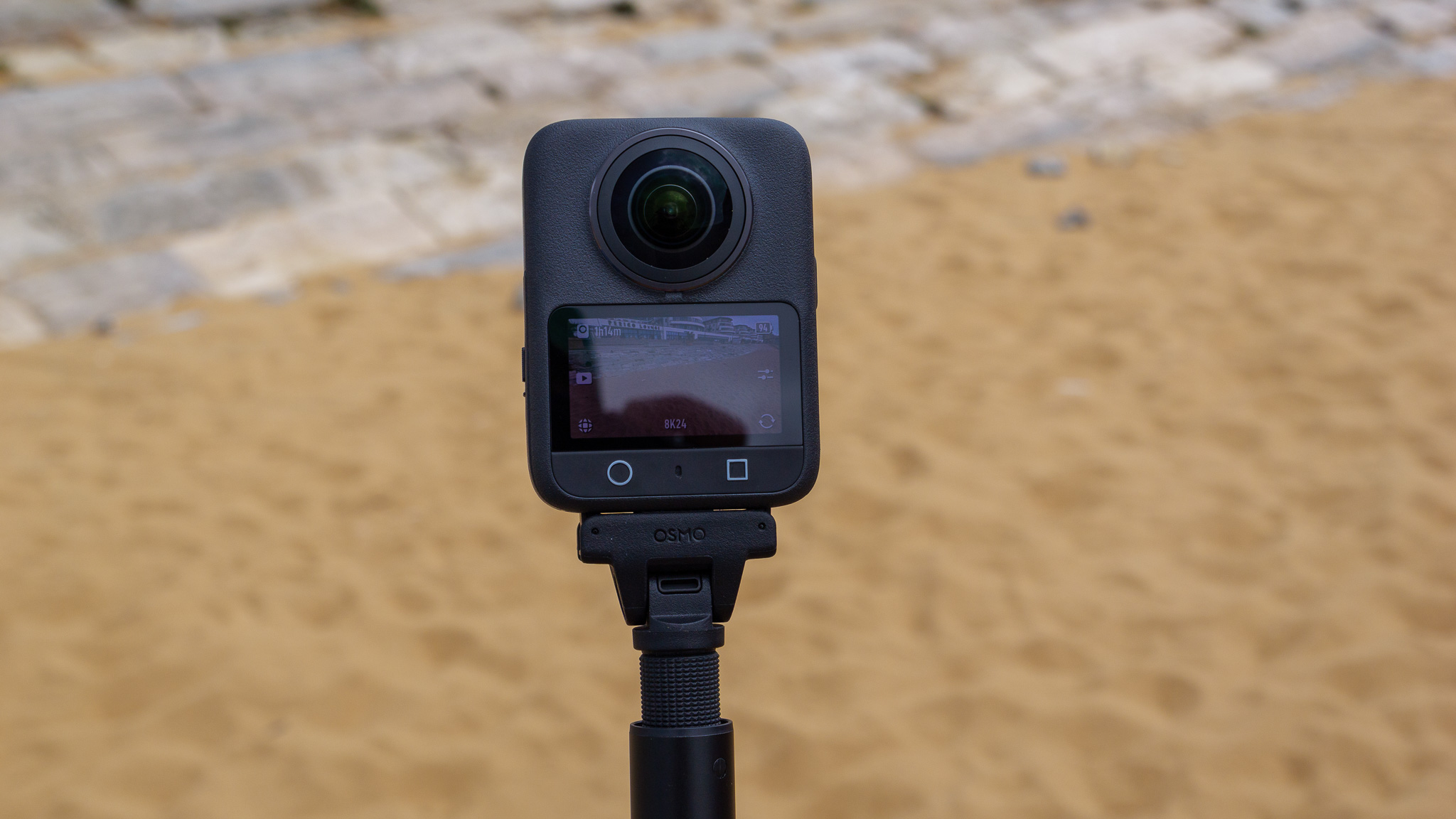 DJI Osmo 360 camera attached to a selfie stick, on the beach