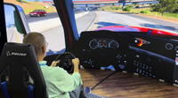SCN's Wayne Cavadi does a driving simulator at the Vanguard booth at InfoComm 2026. 