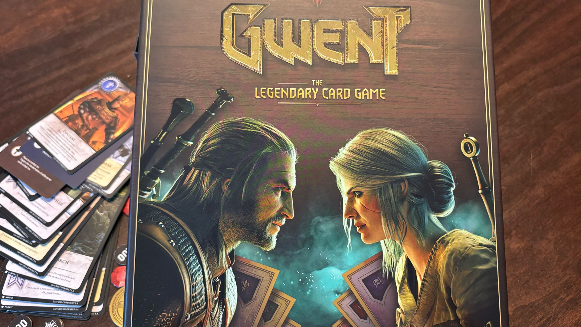 Gwent: The Legendary Card Game box on a wooden surface, with cards visible in the background