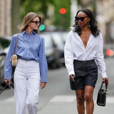 A street-style photo of two women walking outdoors, dressed in a summery fashion