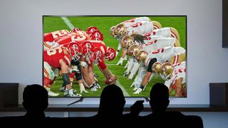 People watch the Chiefs vs 49ers play in the Super Bowl on a 4K TV.