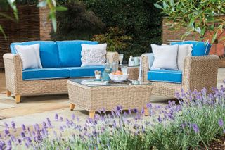 daro blue rattan sofa on patio with coffee table