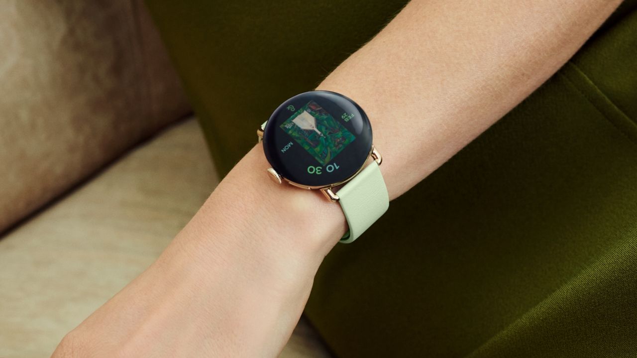A Google Pixel Watch 4 on a model's wrist with a lemongrass band.