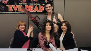 A fan dressed as Ash poses with the Ladies of The Evil Dead in Hail to the Deadites