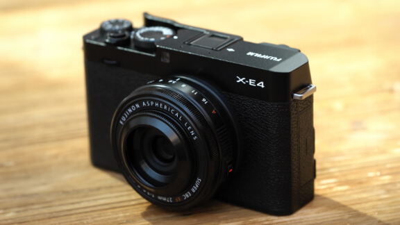 The Fujifilm X-E4 camera sitting on a wooden table