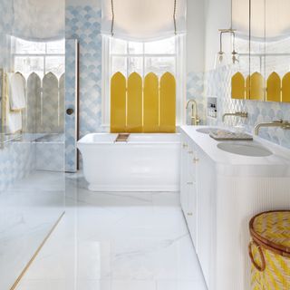 blue and white bathroom with yellow folding screen at the window