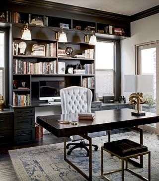 Black and white home office with built-in black shelving and a contemporary desk