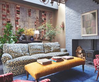 Living room with leopard print armchair and yellow ottoman and log burner