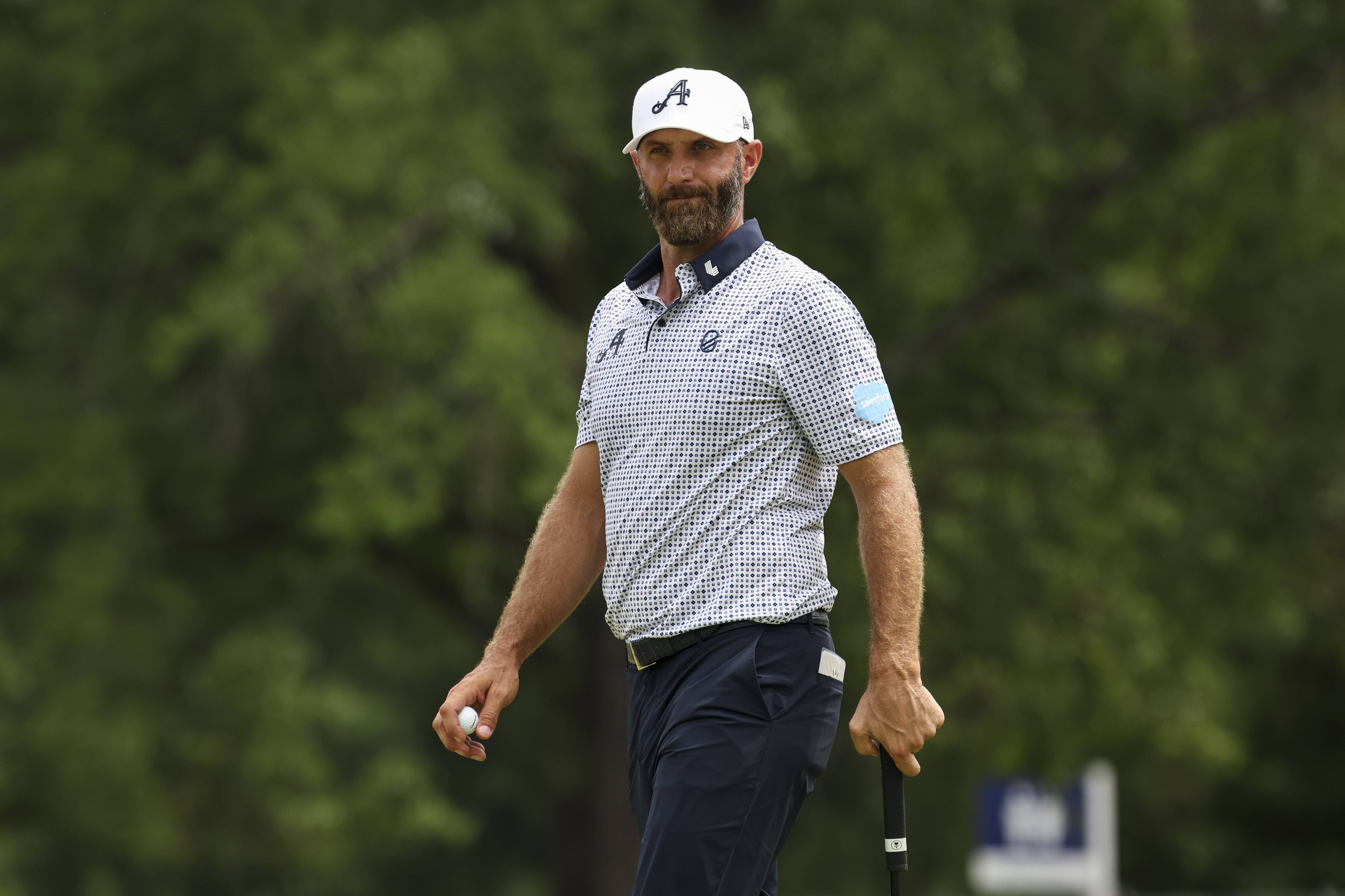 Dustin Johnson stares on while lining up a putt