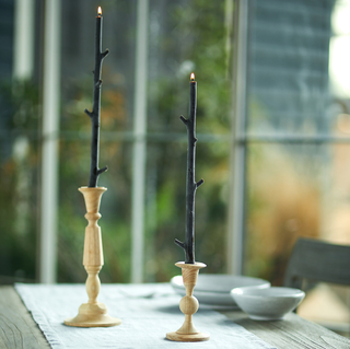 two black tapered candles in the shape of branches
