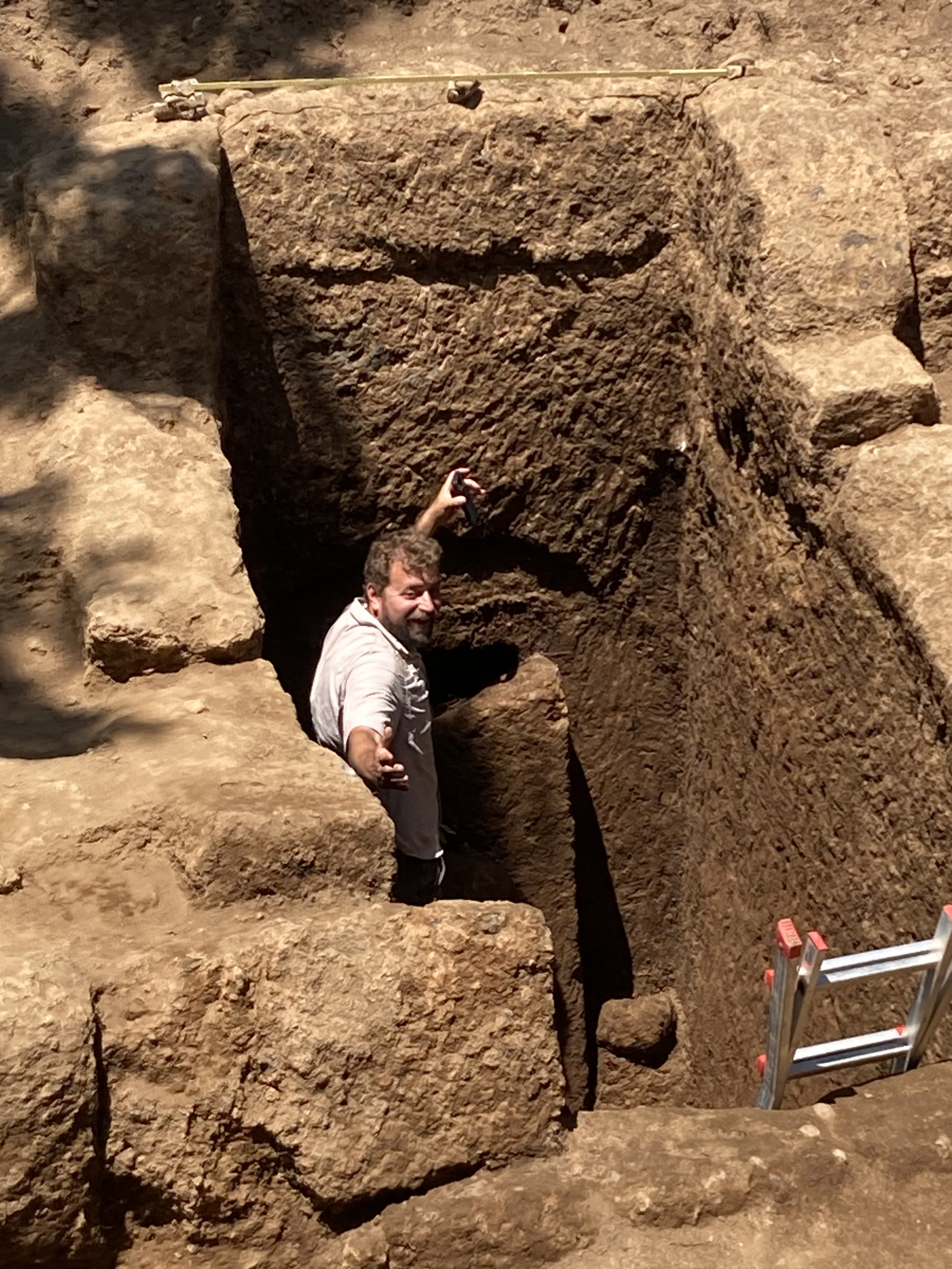 A man stands in a stone-cut tomb.