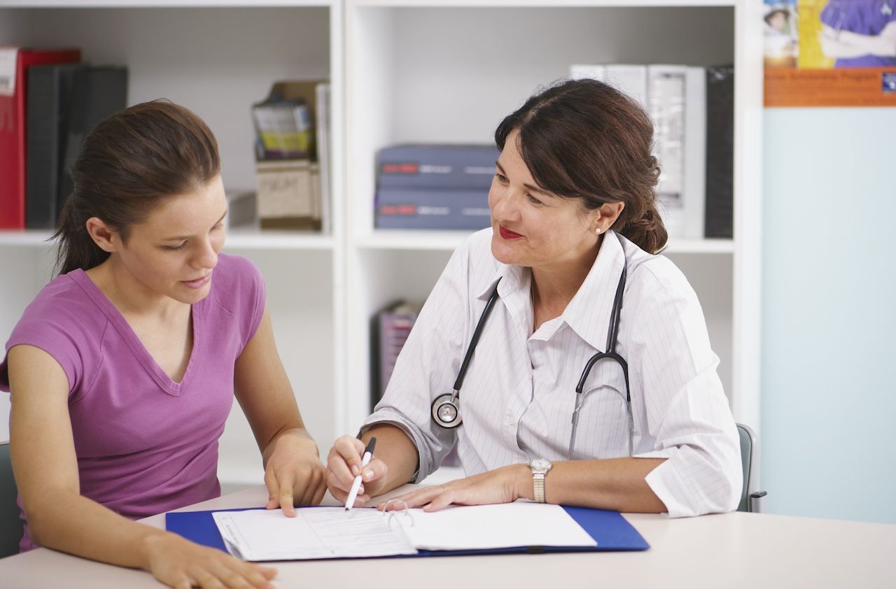 Doctor writing in patient&amp;#039;s chart