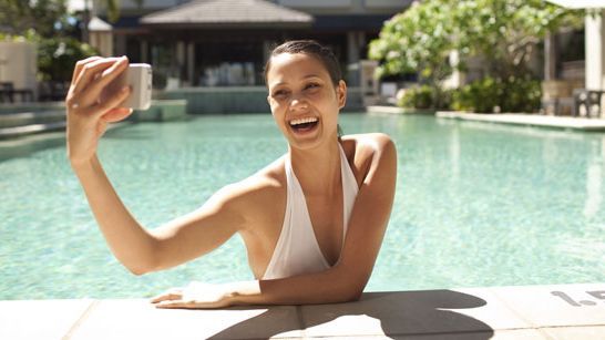 girl in pool taking selfie