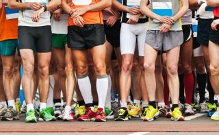 Athletes setting their watches at the start line of a marathon