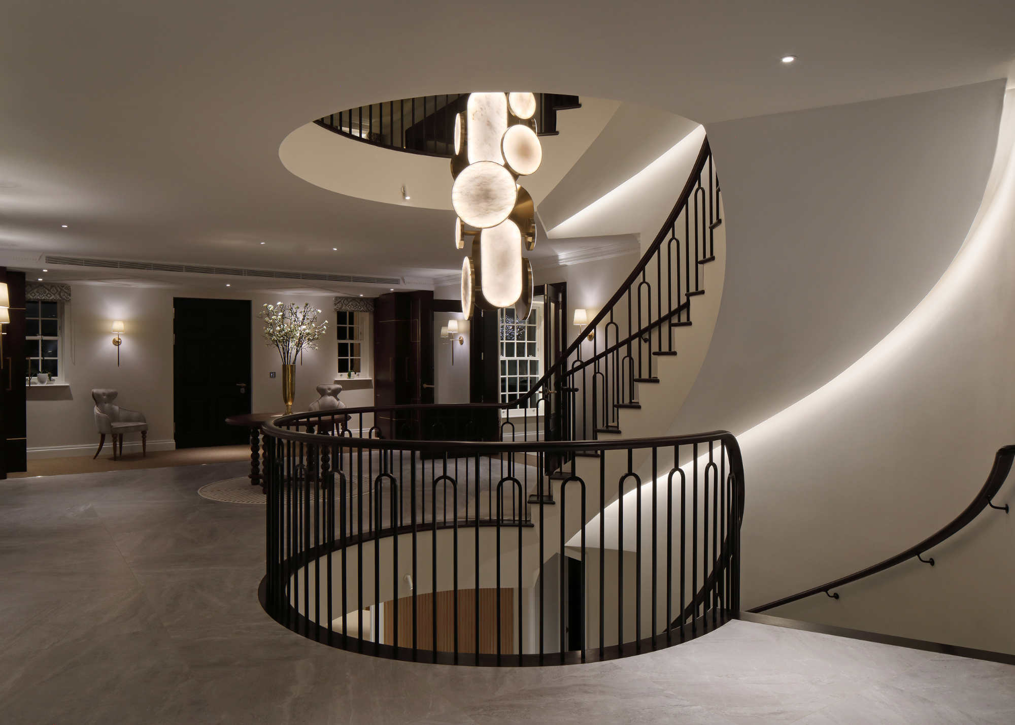 spiral staircase with dramatic light fitting hanging down the middle