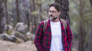 Hiker wearing a flannel shirt and cotton T-shirt in a forest