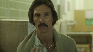 Matthew McConaughey in Dallas Buyers Club holding a vile and looking up with concern.