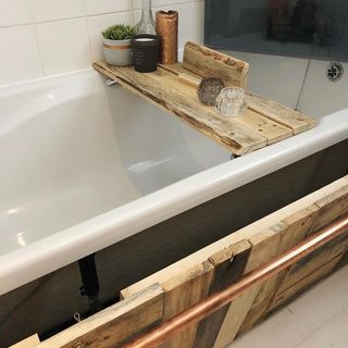white tiled bathroom with bathtub and wooden panels