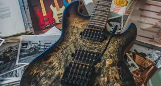 A G&L Custom Shop Rampage sits on a bunch of the brand's ephemera, catalogs, and archive photos