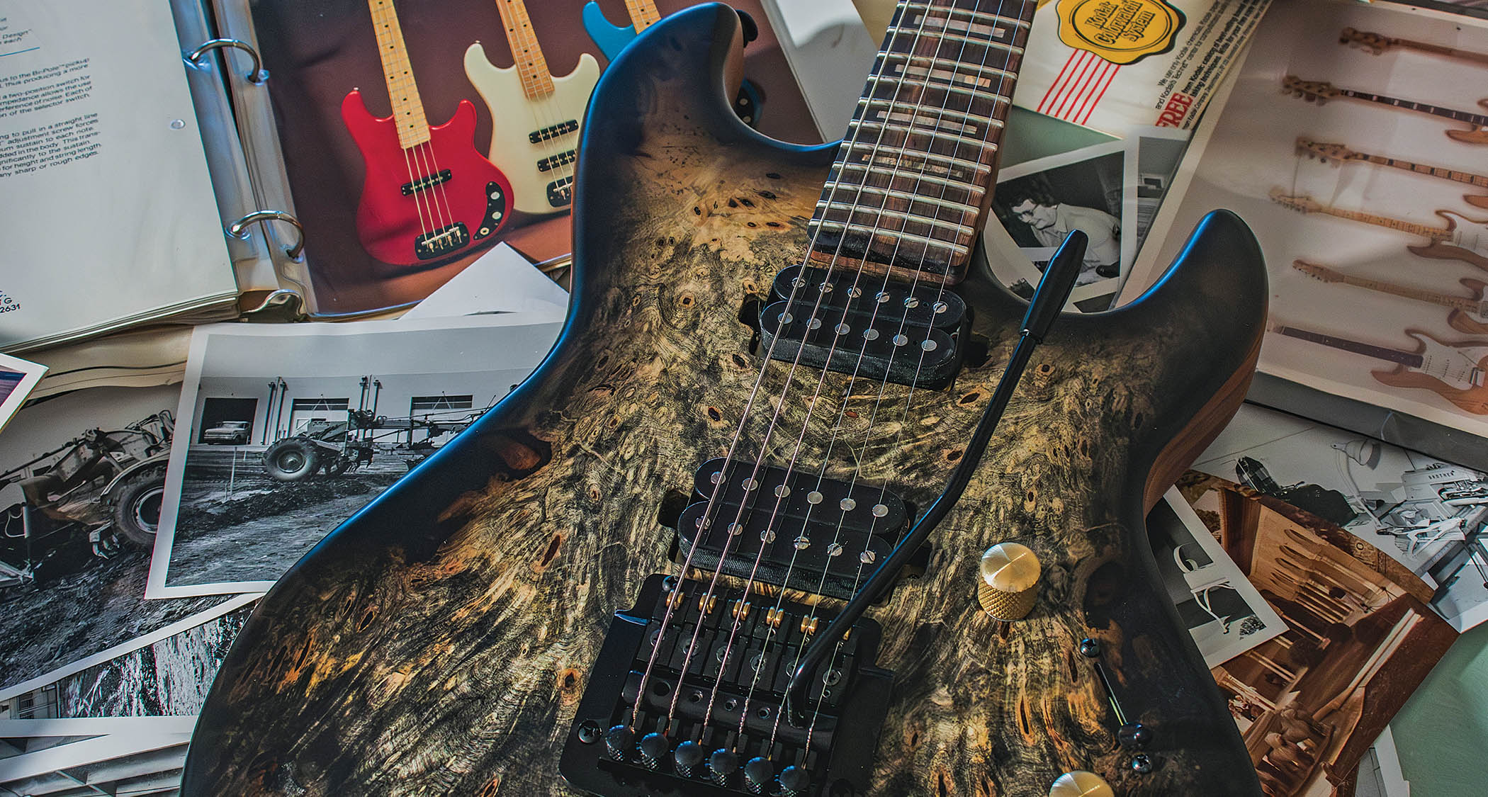 A G&L Custom Shop Rampage sits on a bunch of the brand's ephemera, catalogs, and archive photos
