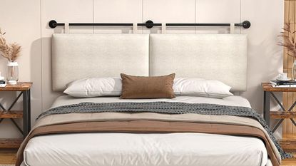 Linen hanging headboard styled with a low slung bed, flanked by wooden nightstands, in a cream-colored bedroom