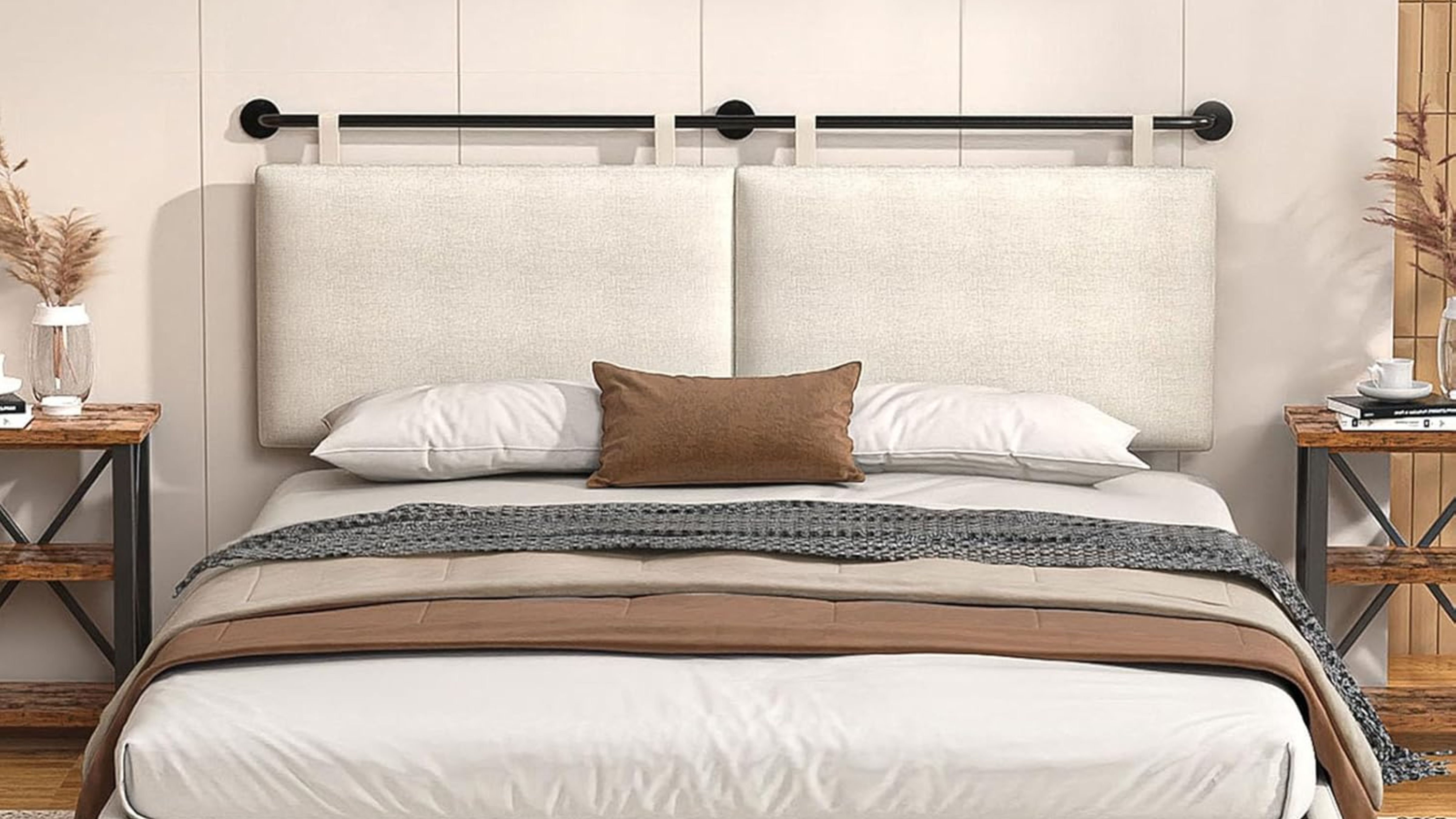 Linen hanging headboard styled with a low slung bed, flanked by wooden nightstands, in a cream-colored bedroom 