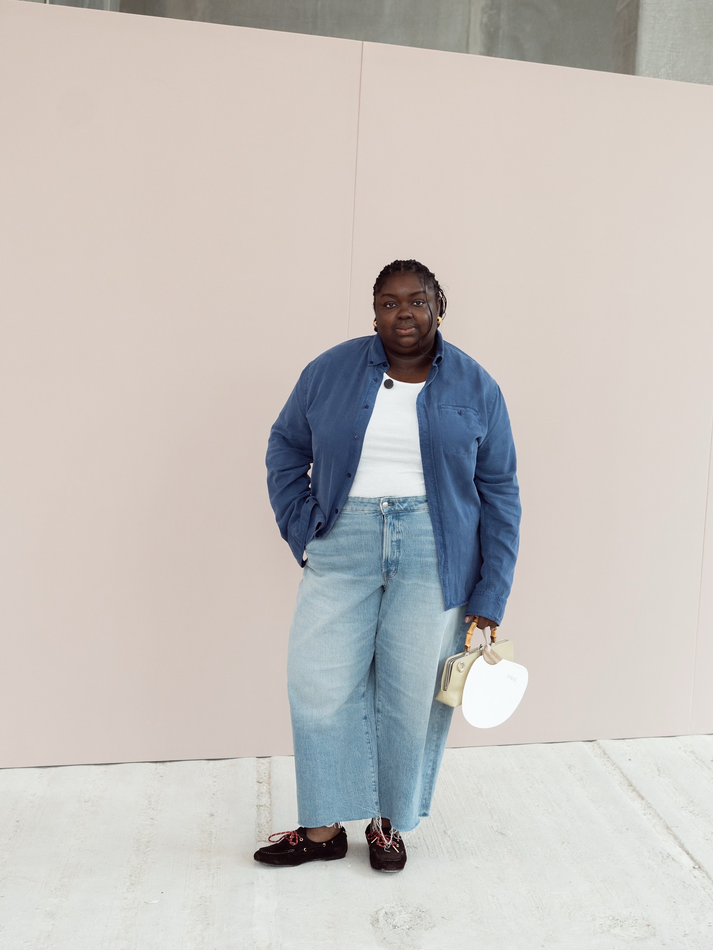 An image of @abimarvel wearing wide-leg trousers with a white t-shirt and button-down shirt.