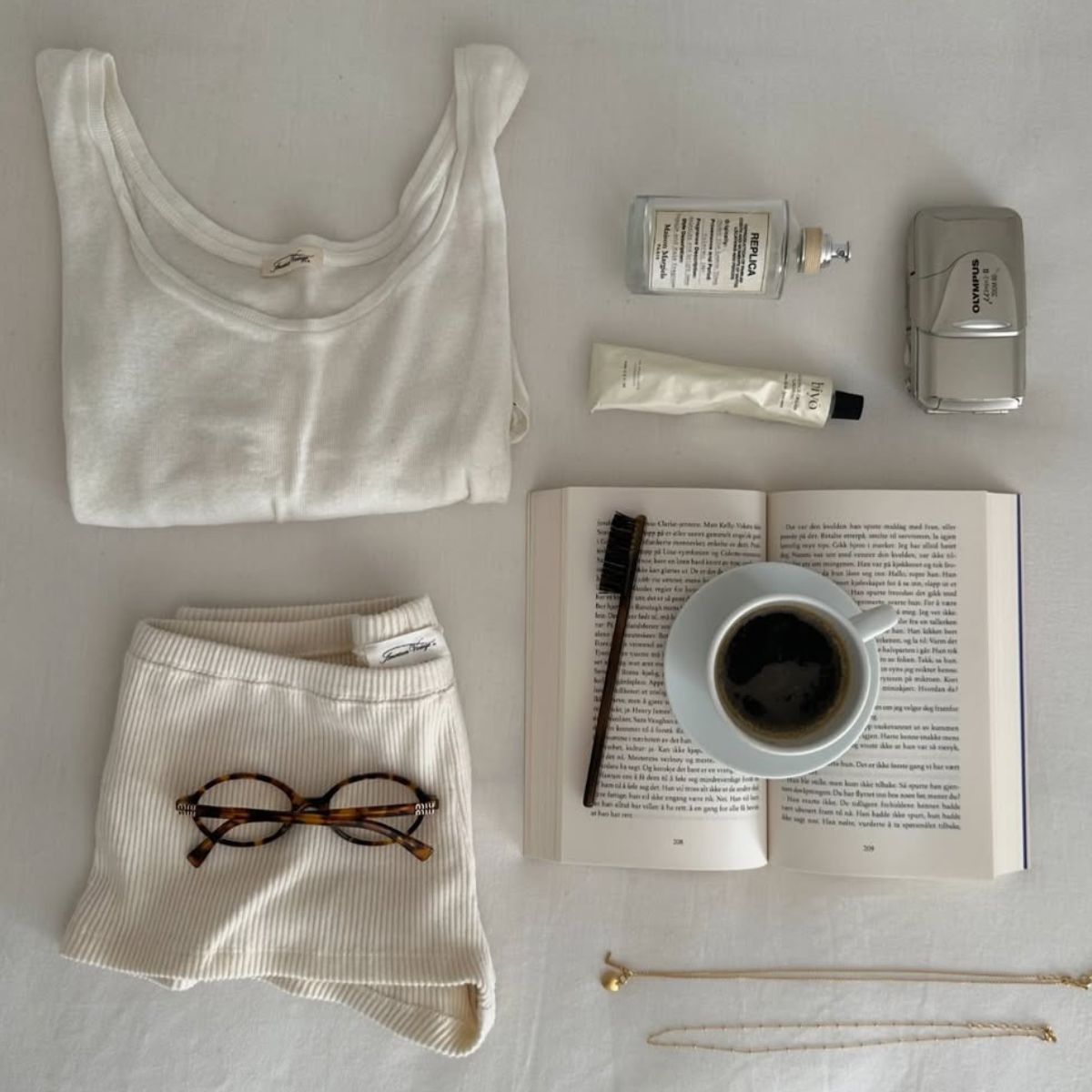 A flatlay image of products on a table, including a Maison Margiela Replica scent.