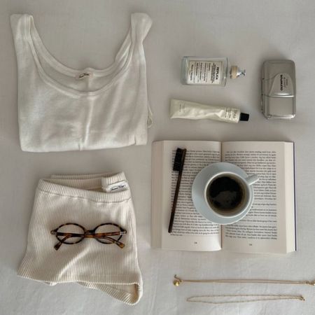 A flatlay image of products on a table, including a Maison Margiela Replica scent.