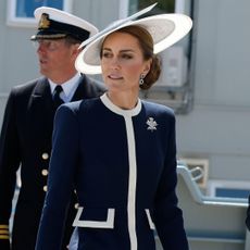 Kate Middleton wearing a blue and white coat and hat