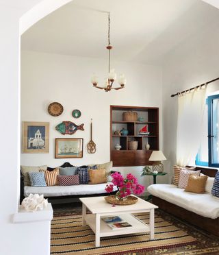 Living room with tall ceiling, couches and white walls with artwork