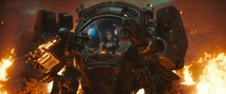 A woman inside an armored robot with flames surrounding her