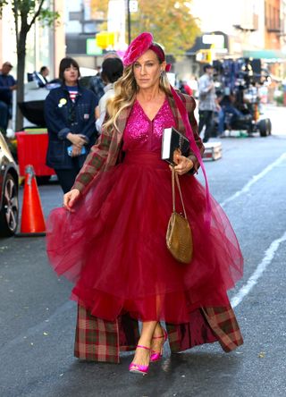 A photo of Sarah Jessica Parker in a pink velvet fascinator carrying a gold croc-embossed bag.