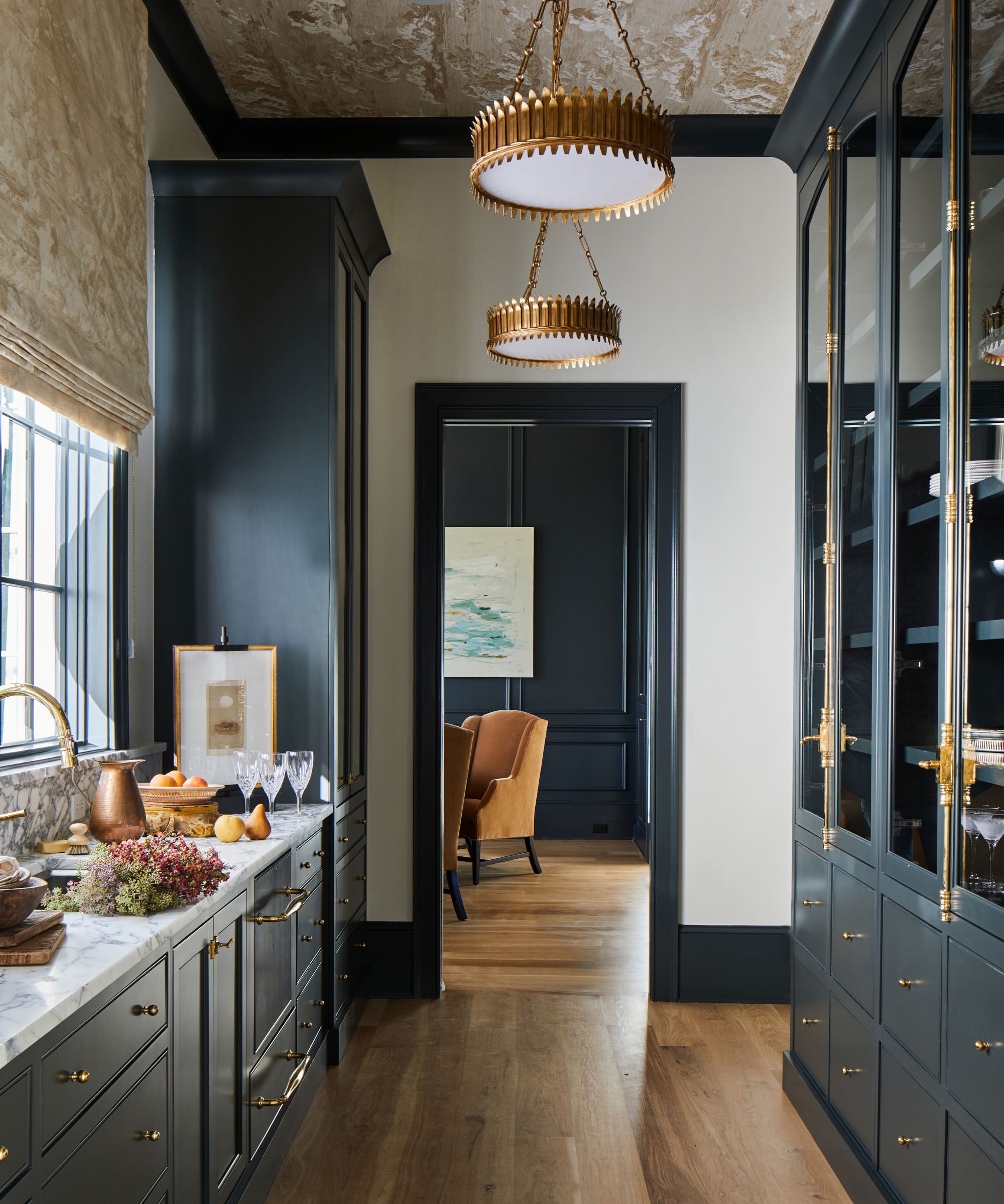 Dark blue back kitchen with marble work tops and a glass fronted cabinet