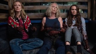 Judy Greer, Jamie Lee Curtis, and Andi Matichak sitting in the back of a truck, bloodied in Halloween 2018.