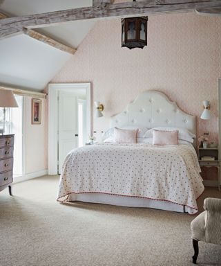 double bedroom with exposed beans and neutral carpet