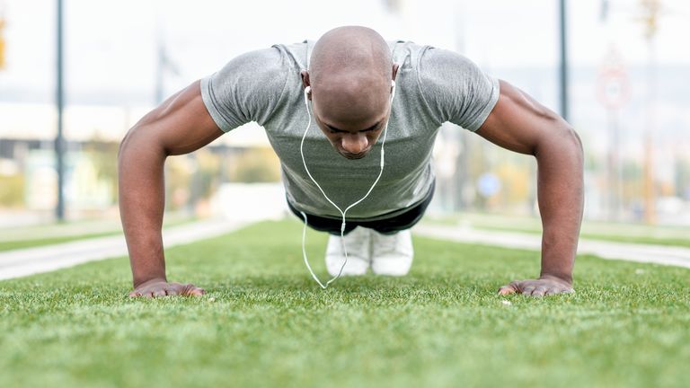 Man learning how to do a push up outdoors
