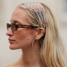 Woman wearing chanel sunglasses and a hairscarf on top of her blonde hair