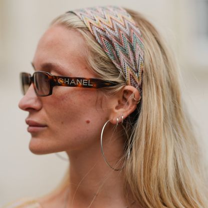 Woman wearing chanel sunglasses and a hairscarf on top of her blonde hair