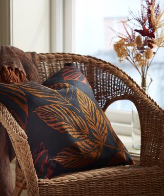 Leaf printed cushion on rattan chair from IKEA’s Höstkväll autumn collection