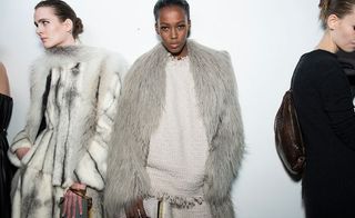 Two models wearing light clothes featuring furs.