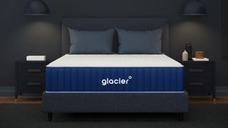 Navy and white Glacier mattress in dark grey bedroom with two grey pillows and grey bed frame