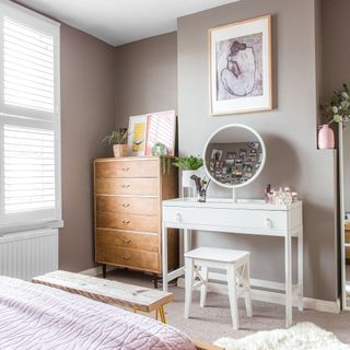 Neutral bedroom with pink bedding, white dressing table and DIY hairpin leg bench